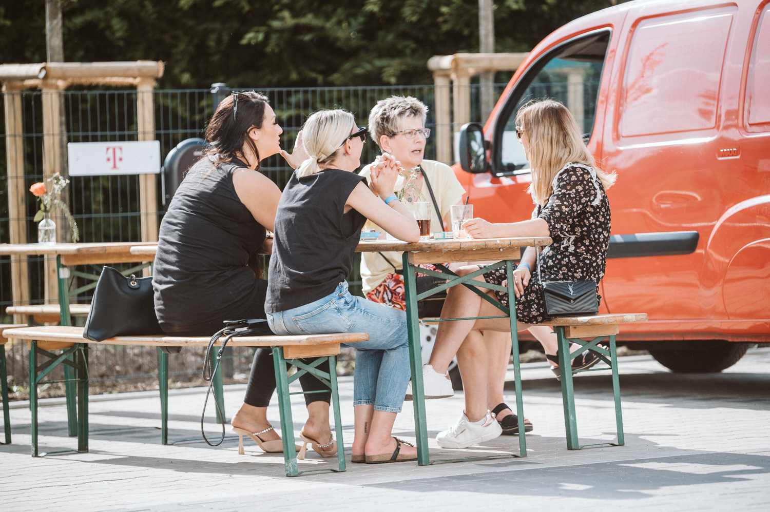 Kollegen sitzen auf Bierbankgarnitur und unterhalten sich