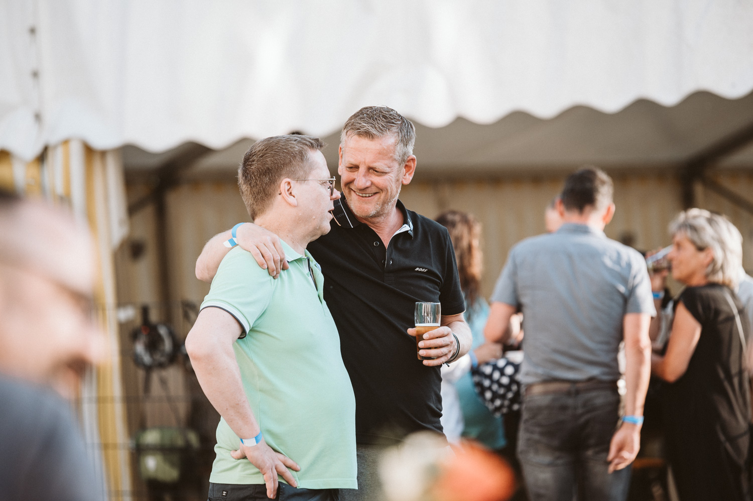 Eventfoto zwei Mitarbeiter Arm auf Schulter