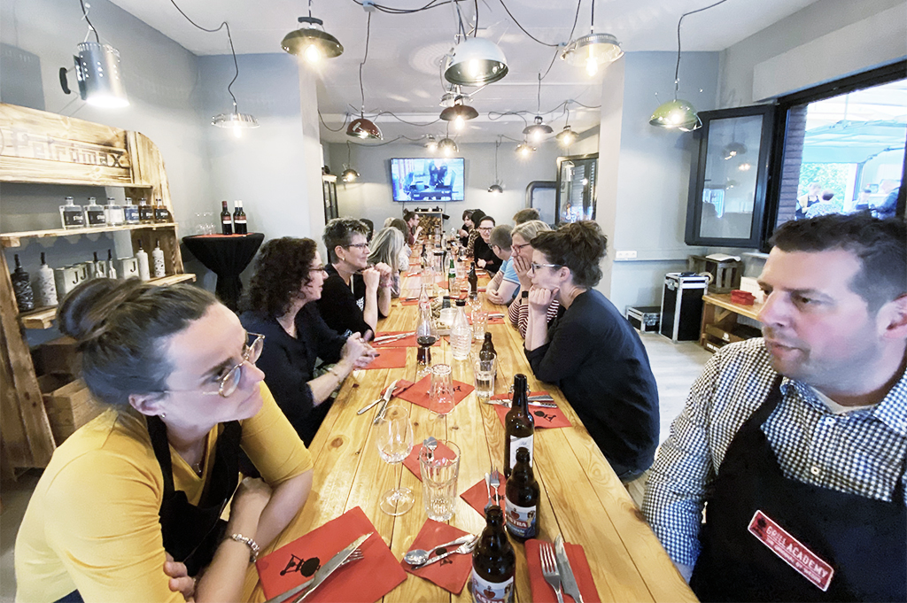 Kochevent Kollegen sitzen an einem großen Tisch